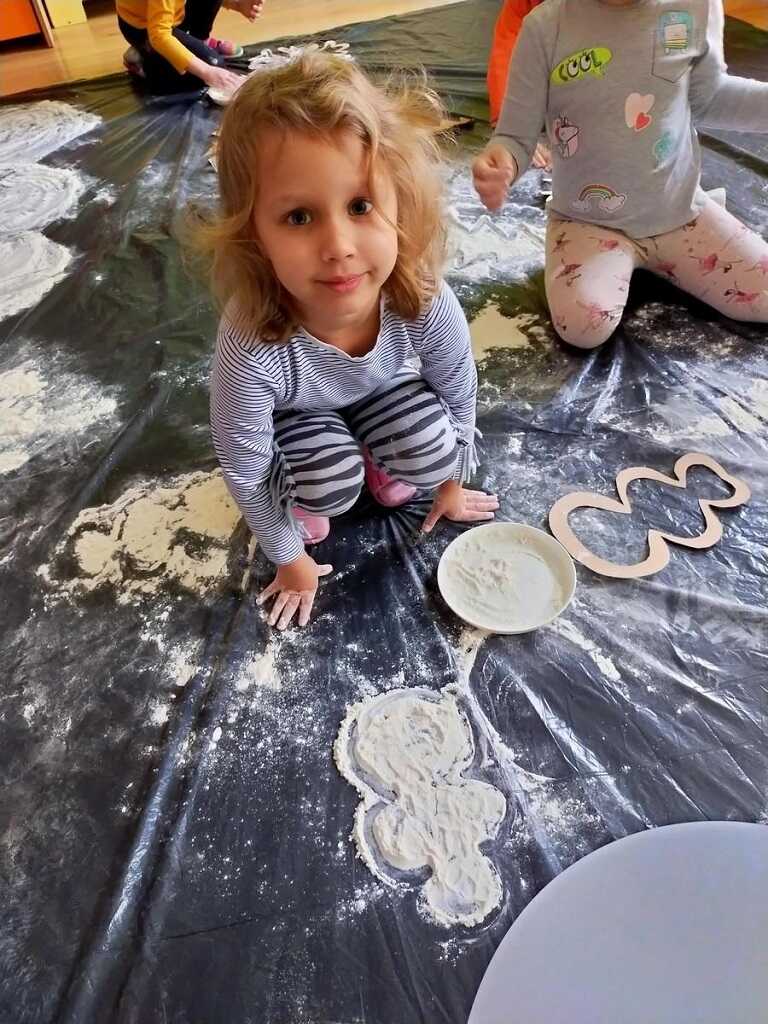 dzieci wykonujące prace plastyczne z mąki