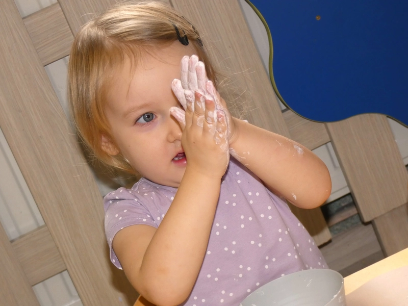 Dziewczynka bawiąca się białą farbą