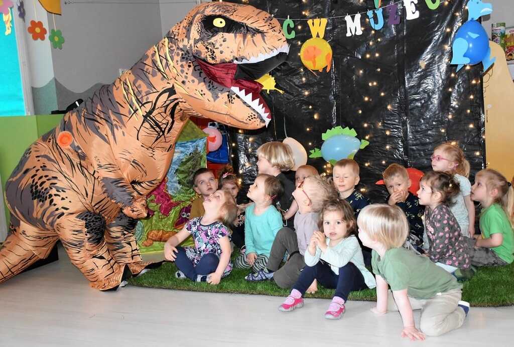 grupa dzieci i nadmuchiwany dinozaur